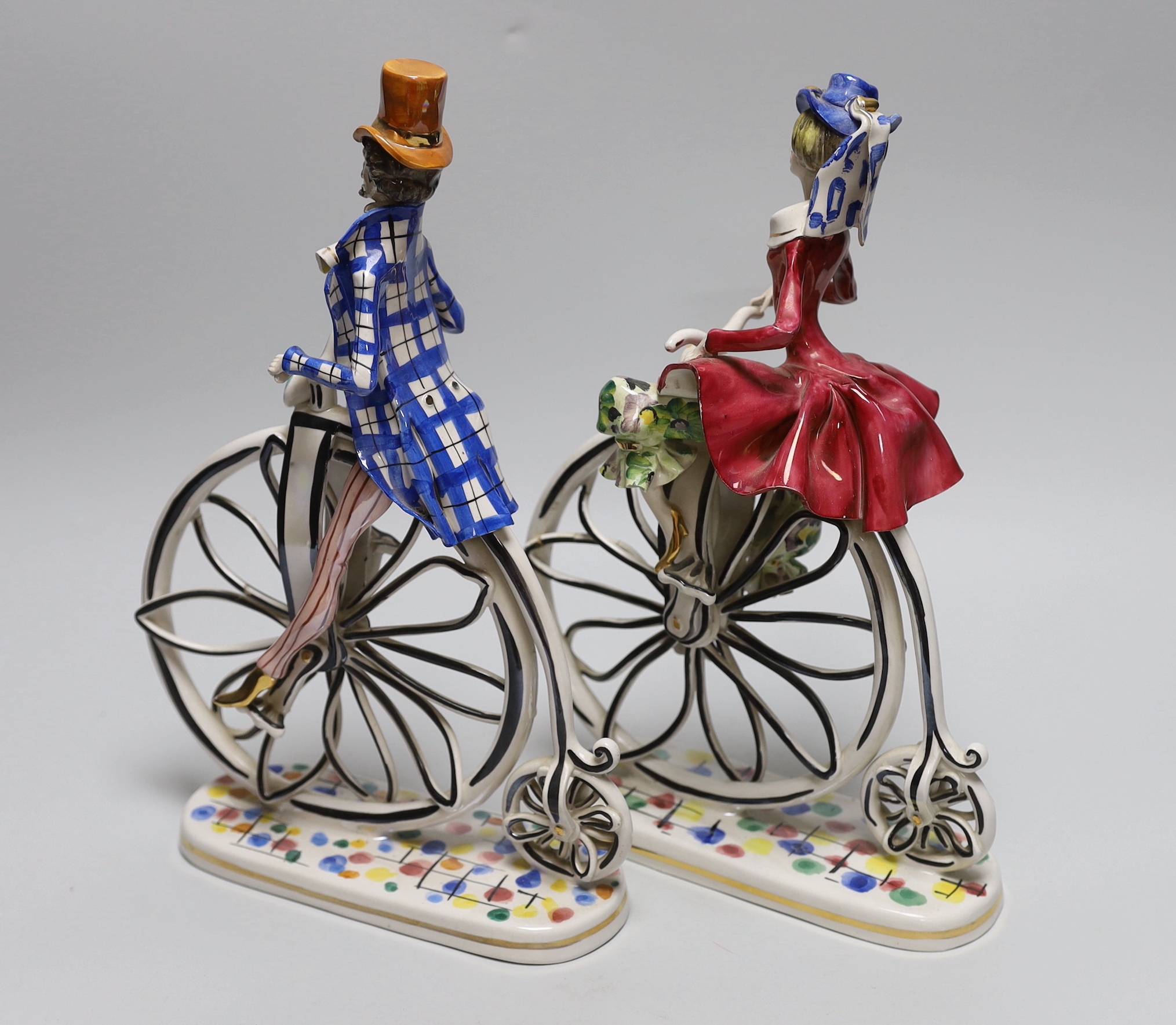 A pair of 1950’s- 60’s Italian ceramic penny farthing cyclists, 31cm